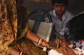 INDIA, Delhi , Applying henna to hands in preparation for wedding.