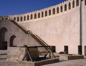 OMAN, Nizwa , Fort interior with cannons and cannon balls placed by the wall.