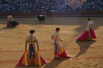SPAIN, Andalucia, Seville, Matador in the Arenal bullring standing in front of the bull with three