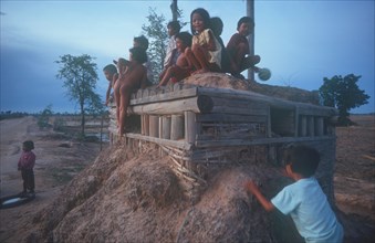 CAMBODIA, Phnom Pehn, Children playing on pillbox gun shelter made of wood and packed earth.