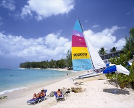 WEST INDIES,   , Barbados, Sandy beach on the West coast fringed with trees and with catamaran and