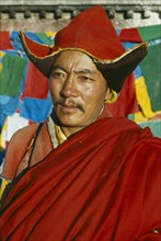 TIBET, Lhasa, Portrait of Buddhist monk in front of prayer flags
