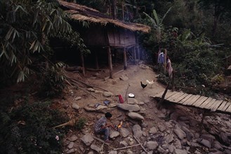 THAILAND, North, Mae Sariang, Karen refugee camp house with chickens outside by wooden bridge and