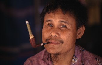 THAILAND, North, Mae Sai, Karen refugee man smoking