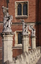 ENGLAND, London, Hampton Court Palace.  Detail of west facade with line of statues of heraldic