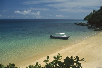 MALAYSIA, East Coast, Pulau Tioman, Small boat moored on the shore of a sandy beach on the west