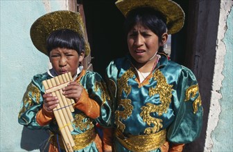 BOLIVIA, Potosi, Two boys in costume blowing pipe