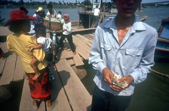 CAMBODIA, Phnom Pehn, "Tonle Sap ferry.  Man taking money in foreground, passengers boarding and