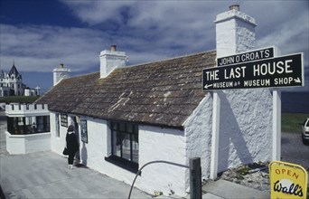 SCOTLAND, Highland , John O'Groats, Woman standing outside The Last House of the Most Northern