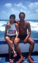 CUBA, People, Couple sitting together on the side of a boat with waves behind