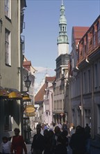 ESTONIA, Tallinn, Shops and a Church with a tower in a street in the Old Town busy with pedestrians