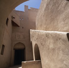 OMAN, Western Hajar, Rustaq, "Fort. Interior view of plain walls, doorway with arch and  blue sky