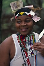 SOUTH AFRICA, KwaZulu Natal, Melmoth, Zulu woman holding a spear with money attached to head wear