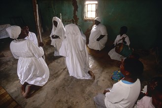 SOUTH AFRICA, KwaZulu Natal, Melmoth, Zulu Zionists women wearing white kneeling on the earth