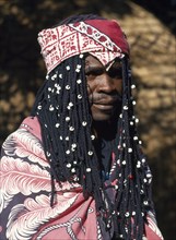 SOUTH AFRICA, Tribal People, Venda Tribesman with long plaited hair decorated with white beads and