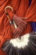 CAMBODIA, Phnom Penh, "Pochentong Airport.  Buddhist monk, detail of hands, robes, umbrella and fan