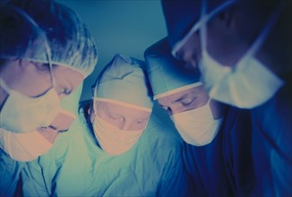 MEDICAL, Doctors, Surgeons, Operating theatre with five medical staff wearing surgical masks