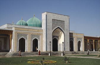 UZBEKISTAN , Near Samarkand, Al Bukhari Mausoleum facade and lawns with passing people