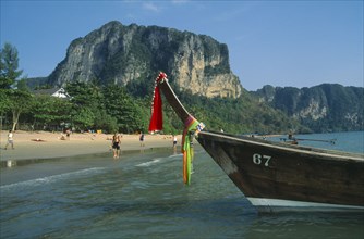 THAILAND, Krabi, Ao Nang Beach, Long tail boat moored in shallow water at the edge of beach with