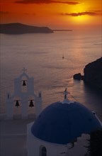 GREECE, Santorini, Thira Church, View across the water at sunset from above the blue and white