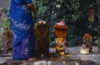 INDIA, Tamil Nadu, Kanchipuram, Devarajaswami Hindu temple.  Cropped shot of woman and offerings