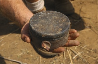 MOZAMBIQUE , Dombe, Man holding Russian Made Anti Personnel Mine.