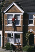 CLEANING, Domestic, Window cleaner on ladder cleaning outside of household windows.
