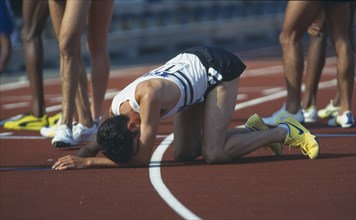 SPORT , Athletics , Track, Exhausted Athlete on his hands and knees