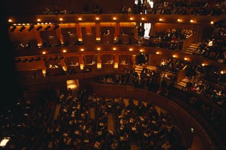 ENGLAND, East Sussex, Glyndebourne , Interior of auditorium with audience members taking their