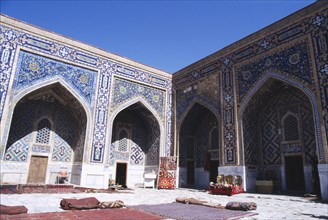 UZBEKISTAN , Samarkand, Registan, Tillya Kari Madrassah courtyard with shops in ornate archways