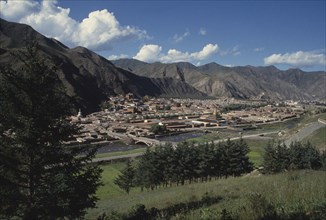CHINA, Gansu, Xiahe, General view over Labrang Monastery from a distance with surrounding hills