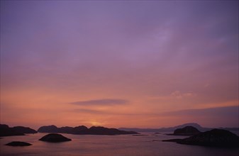 SCOTLAND, Isle Of Iona, View out to sea at sunset over small islands