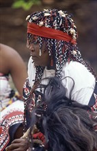 SOUTH AFRICA, KwaZulu Natal, Local woman in traditional headress holding fly whisk made from