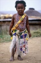 SOUTH AFRICA, KwaZulu Natal, Melmoth, Young Zulu Girl dressed up by her sisters in traditional