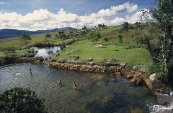 SOUTH AFRICA, Mpumalanga, Near Grasskop, MacMac pools with people bathing grassland behind.