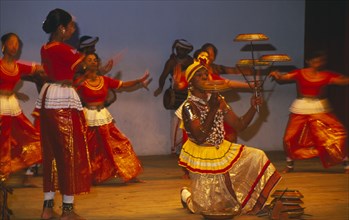 SRI LANKA, Kandy Dancers, Traditional dancers and man spinning plates on poles and fingers on stage