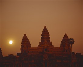 CAMBODIA, Angkor, Angkor Wat Complex. Triple pagodas of main temple silhouetted at moonrise.