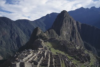 PERU, Cusco, Machu Picchu, View over ruined Inca city and surrounding mountain landscape