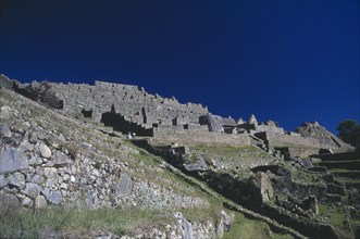 PERU, Cusco, Machu Picchu, View looking up slope toward hillside Inca city ruins