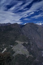 PERU, Cusco, Machu Picchu, Aerial view over mountain landscape with hilltop Inca city ruins