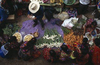 GUATEMALA, Chichicastenango , View looking down on market scene with people sitting at a vegetable