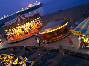 ENGLAND, East Sussex, Brighton, Seafront amusements and Brighton Pier illuminated at night