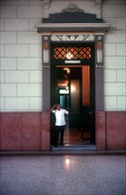 CUBA, Havana , University interior with man standing in hallway entrance