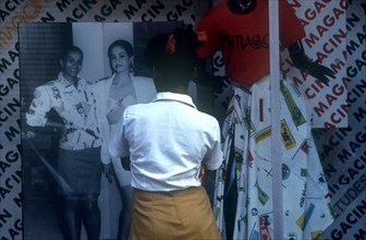 CUBA,  , Havana, School girl standing at fashion shop window