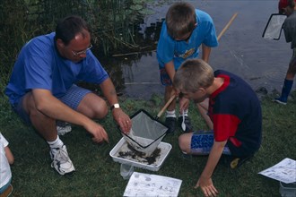 EDUCATION , Primary, Field Trip, "Pond Dipping activity. Children with adult inspecting a fishing