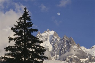 FRANCE, Rhone Alps , Chamonix, Haute Savoie. Snow covered Alps with Moon visible in the sky