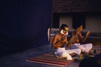 INDIA, Kerala , Kathkali dancers applying make up.