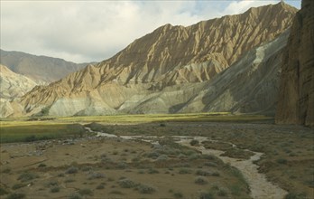CHINA, Qinghai  , Yellow River , Eroded rocks above wheat fieldin  high altitude remote valley