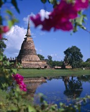 THAILAND, Central Plains, Sukhothai, Bell shaped temple(Wat)through flowers-reflection