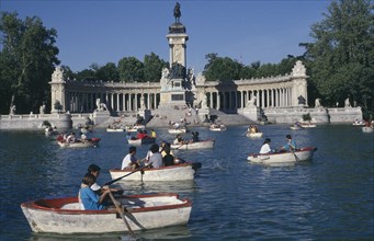 SPAIN, Madrid , El Retiro Park. View over the busy boating lake toward column with equestrian